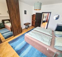 A bedroom in a 3-room apartment with a bed, a mirrored wardrobe, and a blue carpet.
