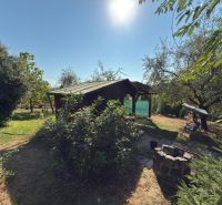 Cottage on the Vineyard in Lučenec surrounded by greenery and trees, with a fire pit in the garden.
