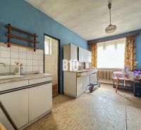 A kitchen in a family house with furniture and flooring featuring a wood design.