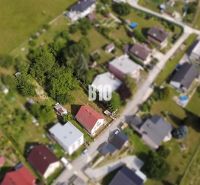 Aerial view of a family house in Považská Bystrica surrounded by greenery and other houses.