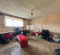 Room in a family house with wallpaper, lots of things, and a baby stroller.