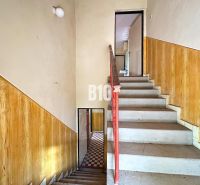 A staircase with a railing and walls with wooden decor in a family house.