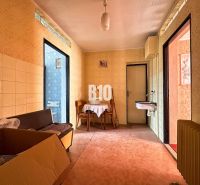 Interior of a family house with a sink, table, and a box on the floor with a wooden decor.