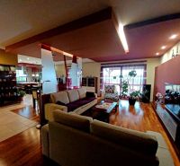 Living room in a family house with a wooden decor floor and comfortable seating.