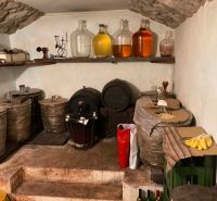 A cellar in the cottage with barrels and demijohns on the shelf.