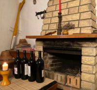 In the chalet, there is a brick fireplace, wine bottles, and a candle on the table.