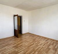 A room in a family house with a wooden decor floor and open doors.