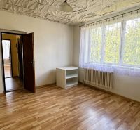 A room with a wooden decor floor, a cabinet, and a painting on the wall in a family house.