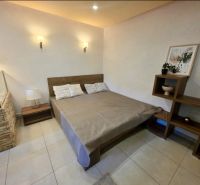 Bedroom in a studio apartment with stylish decor, wooden elements, spacious bed.