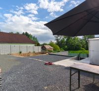 A courtyard with a stone surface and a large sunshade at the Recreational Grounds in Záhorce, Selešťany.
