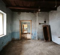A room in a family house with blue walls, an old sewing machine, and a wooden trough.