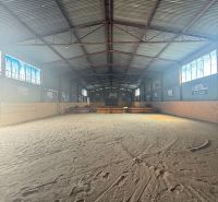The interior of a building with a large spacious playground and a metal roof.