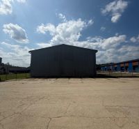 A building in Hniezdne with a large paved area and a blue sky.