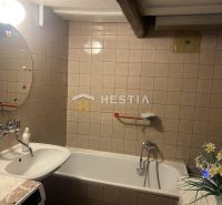 Bathroom with a bathtub, sink, and mirror with decoration in a family house.