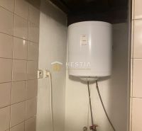 A boiler in a family house with ceramic tiles on the wall.