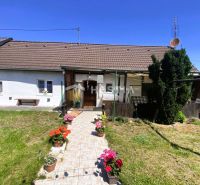 A family house in Borský Mikuláš with a garden and flowers in pots in front of the veranda.