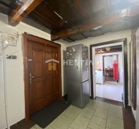 Interior of a family house with a wooden ceiling, hallway, and kitchen.