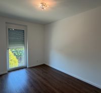 A room in a 3-room apartment with white walls and a wooden decor floor.
