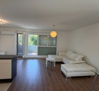 Living room in a 3-room apartment with a white sofa and a floor with a wooden decor.