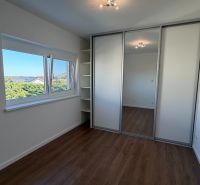 A room in a 3-room apartment with a wood-patterned floor and a built-in wardrobe.