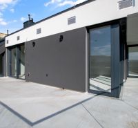 Spacious terrace of a 5 or more room apartment with a modern facade and glass railing.