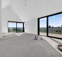 A spacious room in a 5 or more bedroom apartment with large windows and a concrete floor.