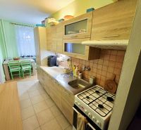 A kitchen in a 4-room apartment with a wooden decor and a dining nook.