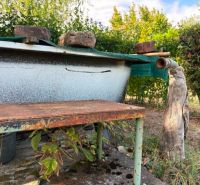 Gardens of Komárno with a metal structure, a bench, and natural elements.