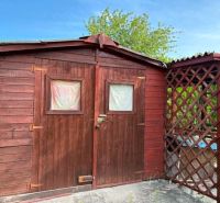 A wooden garden house with a covered shelter in the Gardens of Komárno.