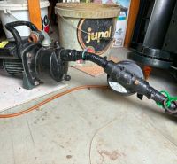 Pump and hose on a floor with a wooden decor in the Gardens.