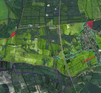 Aerial view of agricultural and forest lands in the village of Závod with road infrastructure.