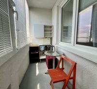 A balcony with seating and furniture in a studio apartment.