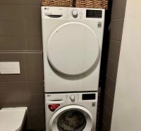 Bathroom in a 2-room apartment with an LG washer and dryer, laundry baskets.