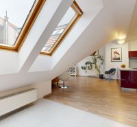 Attic interior of a 4-room apartment with large skylights and a kitchen.