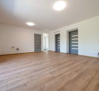 Living room in a family house with a wooden decor floor and white walls.