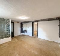 A room in a family house with a glass block wall and wiring on the wall.
