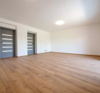 A room in a family house with a wooden decor floor and gray doors.