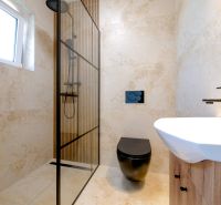 A bathroom in a family house with a modern shower and a black toilet.