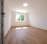 A room in a family house with white walls and a floor with a wooden decor.