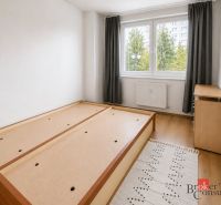 Bright bedroom in a 2-room apartment with a bed and wood-patterned flooring.