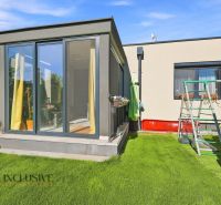 A family house in Oľdza with a terrace and a children's playground on green grass.