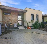 A family house in Oľdza with a terrace, flowers, and comfortable seating in front of the entrance.