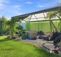 The garden of a family house in Oľdza with a pergola, curtains, and a swing for relaxation.