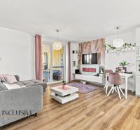 Living room with a comfortable sofa, TV, dining table, and wooden decor flooring in a family house.