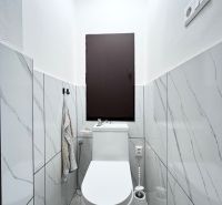 WC in a 3-room apartment with marble tiles and white sanitary ware.