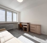 Living room with a desk and a sofa, wooden decor flooring in a 3-room apartment.