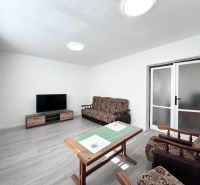 Living room in a 3-room apartment with a wooden decor floor and furnishings.