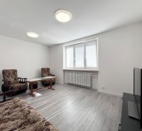 Living room in a 3-room apartment with furniture, a television, and a wooden decor floor.