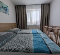 A bright bedroom with a bed and a crib in a 2-room apartment.