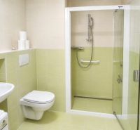 A bathroom in a 2-room apartment with a shower and light tiles.